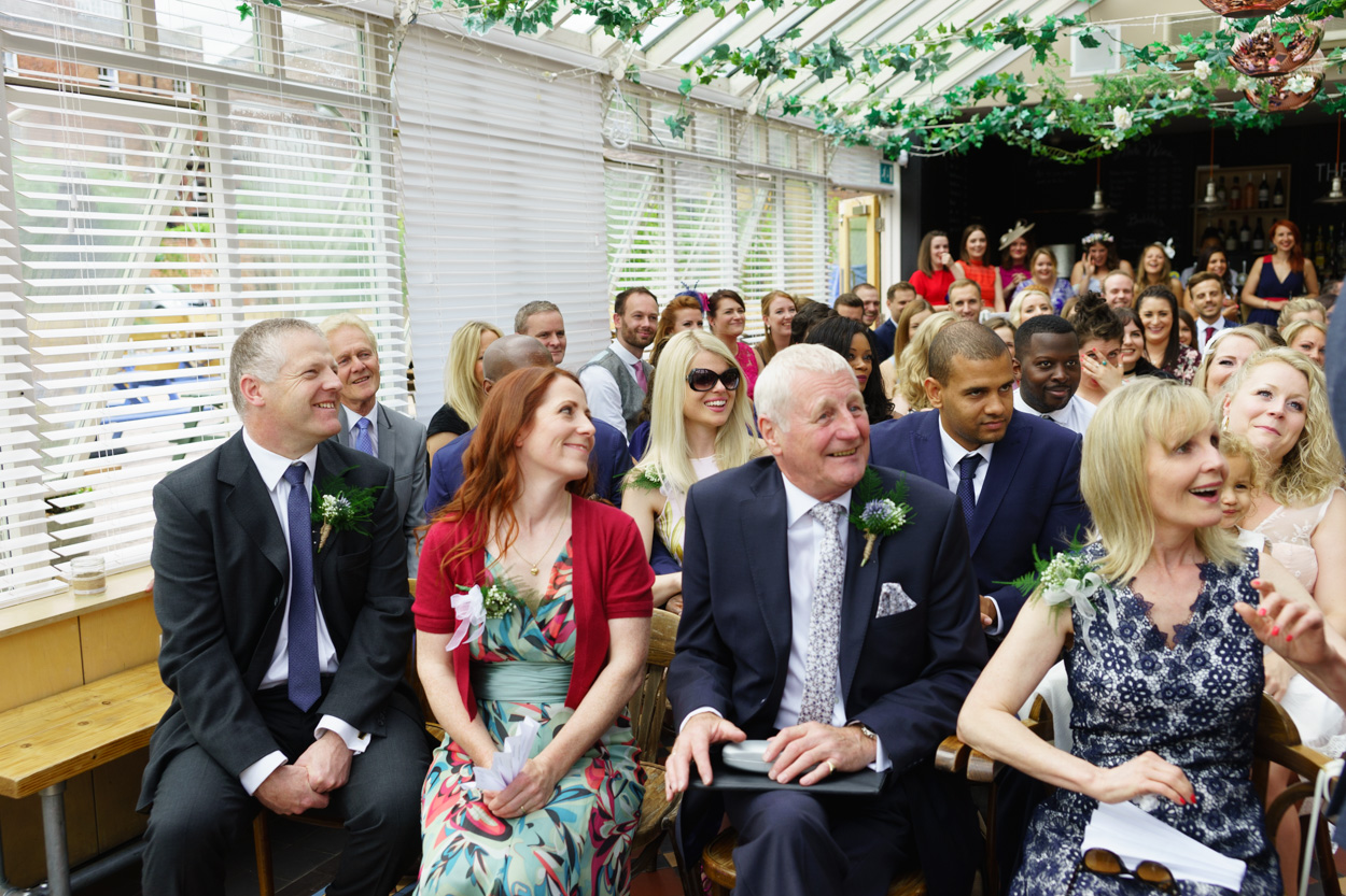 Guests smiling during a joyful wedding ceremony