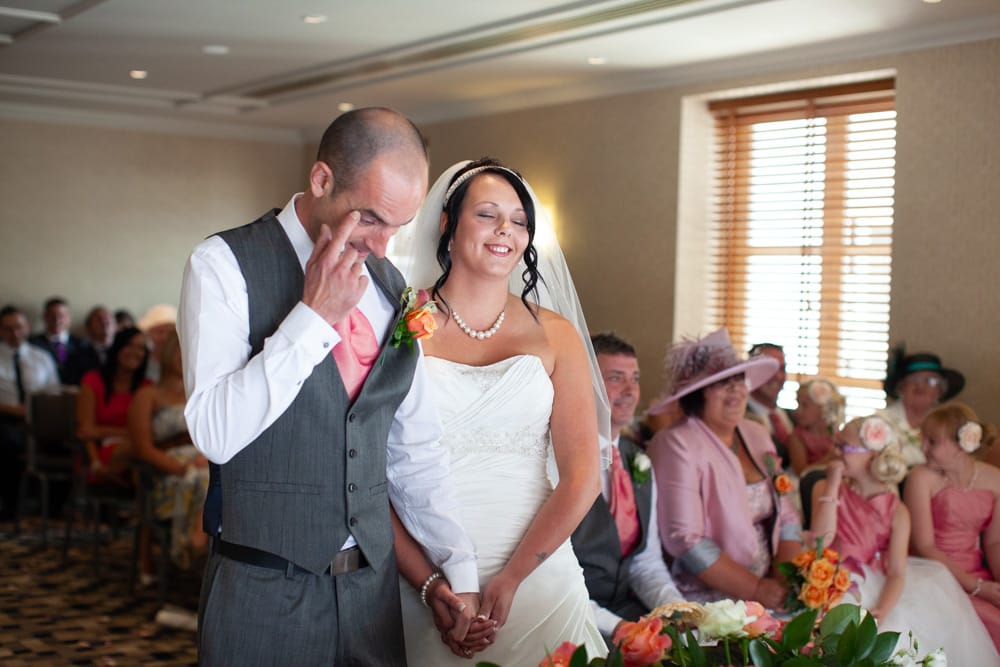 Guests and couple smile with surprise and joy during a heartfelt reading.