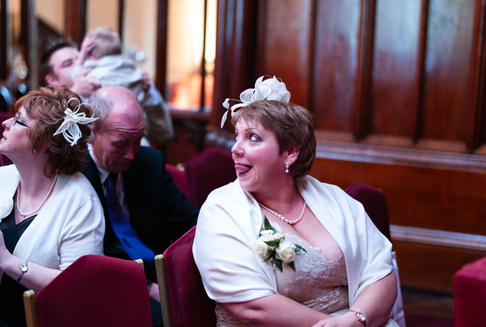 Mother of the bride watches from above, tongue gently pressed to her lip in anticipation.
