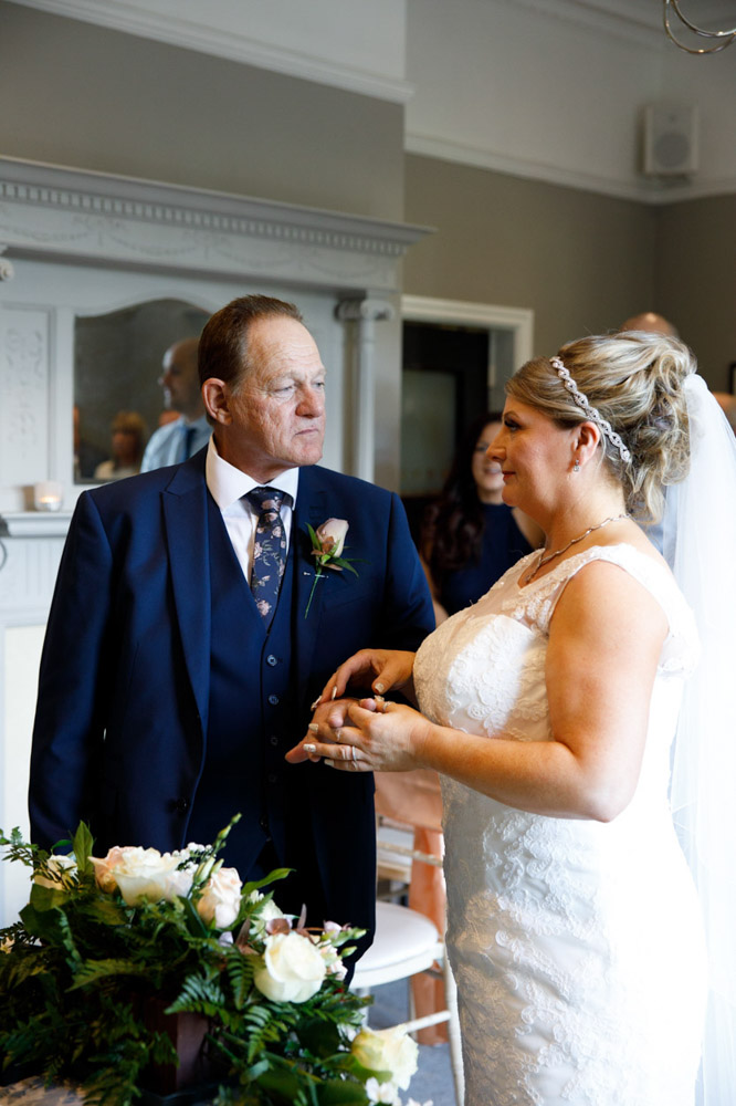 Tracy places the ring on Gary’s finger while he smiles proudly