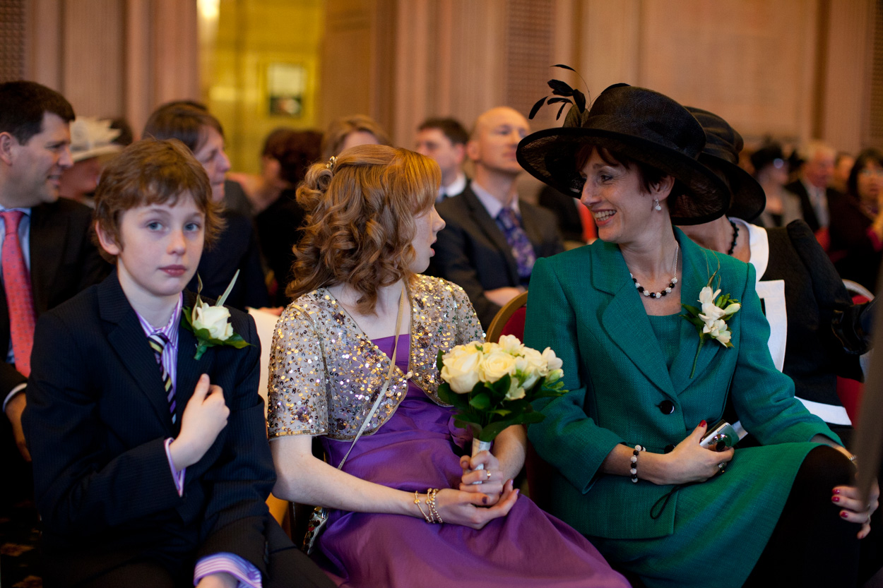Groom’s son and guests on the front row smiling during the signing.