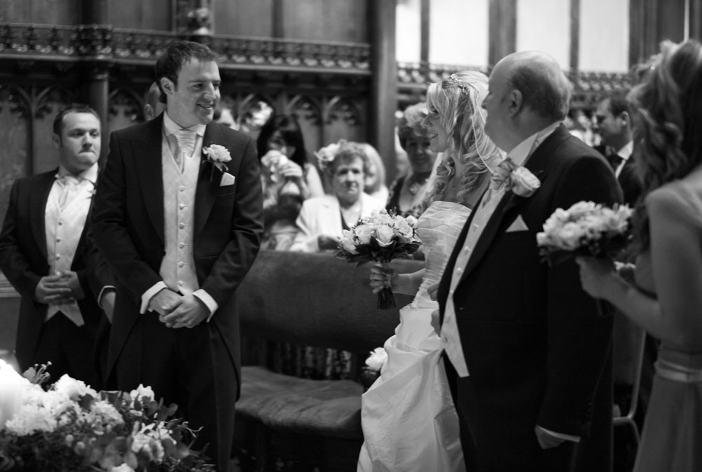 The bride and groom share a smile as she arrives with her father at the ceremony.