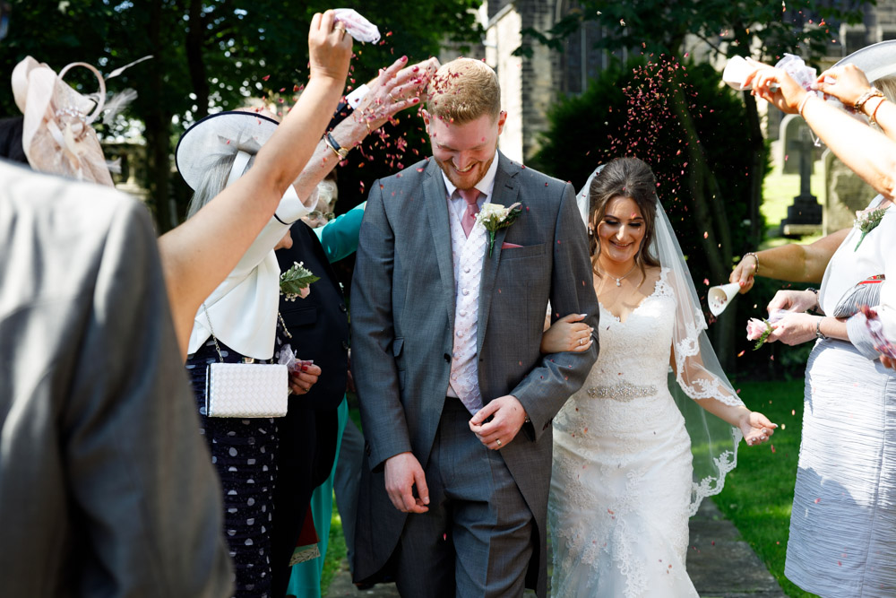 The couple begin the confetti walk at St Oswald’s Church, with guests throwing dried petals.