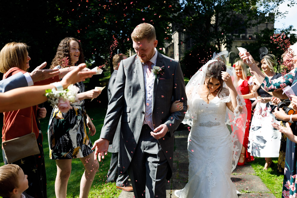 Matt and Kyra cover their faces playfully as the confetti continues.
