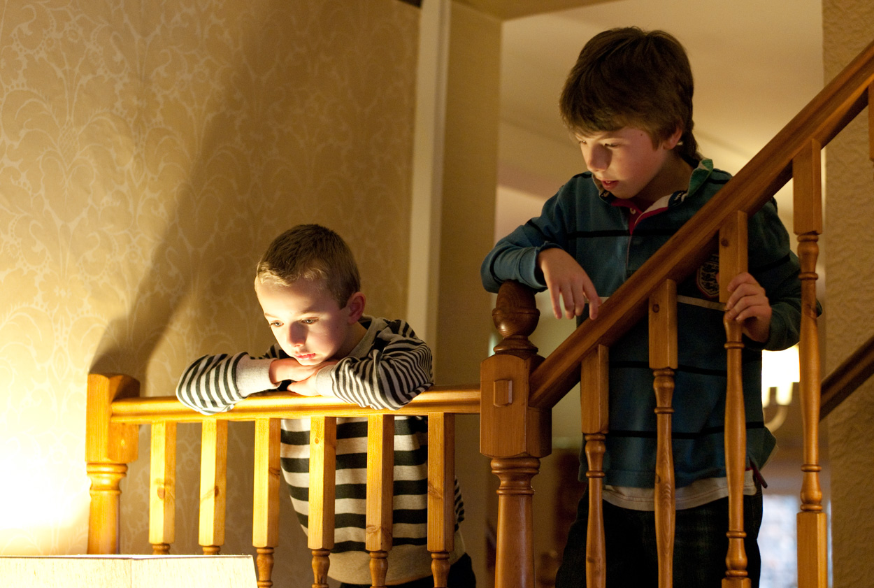 The couple resting arms on the bannister watching guests arrive