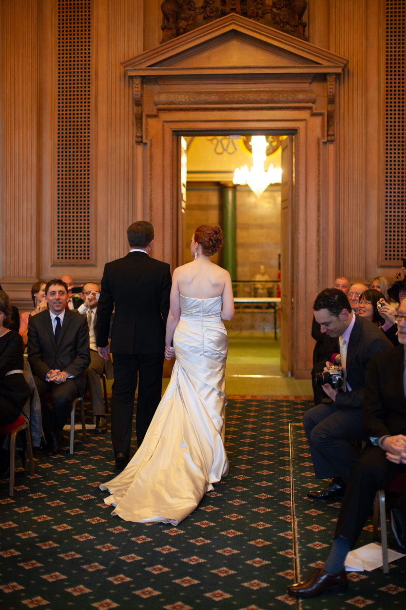 Bride and groom approaching the tall entrance doors of the Banquet Hall at Leeds Civic Hall.