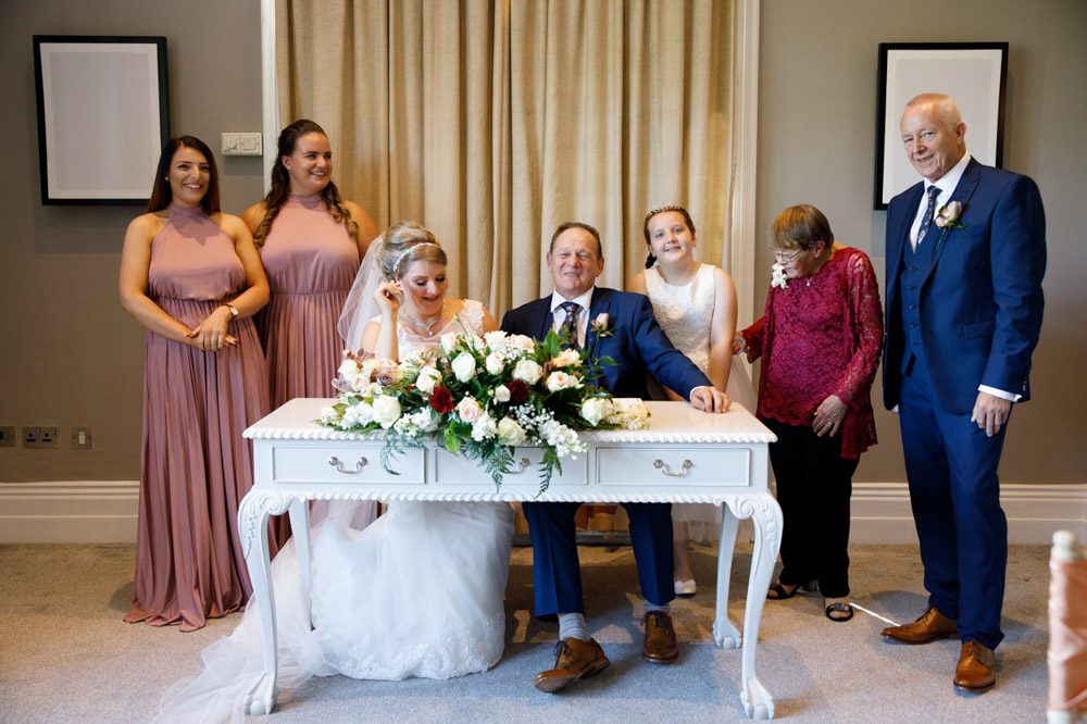 Bridal party gathered by the register table for a group photo