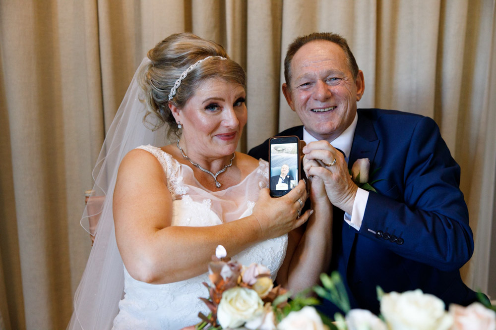 Elderly relative joins via Skype on a phone, held up beside the couple
