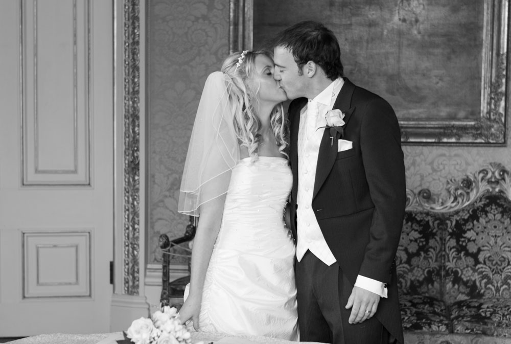 Bride and groom kiss again in the boardroom after signing the register.