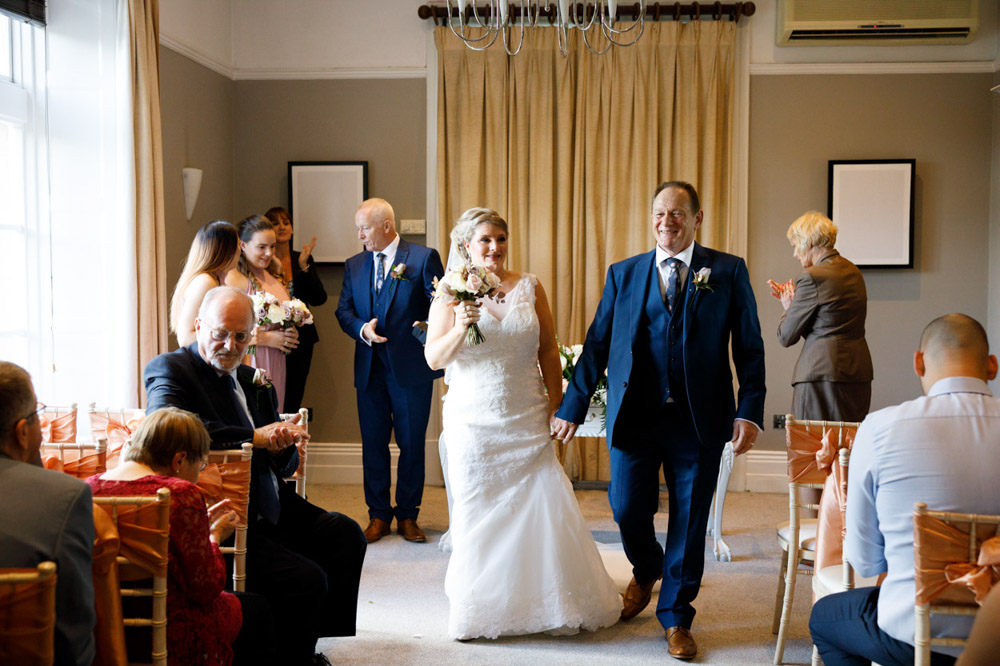 Couple begin their exit as newlyweds from the ceremony room