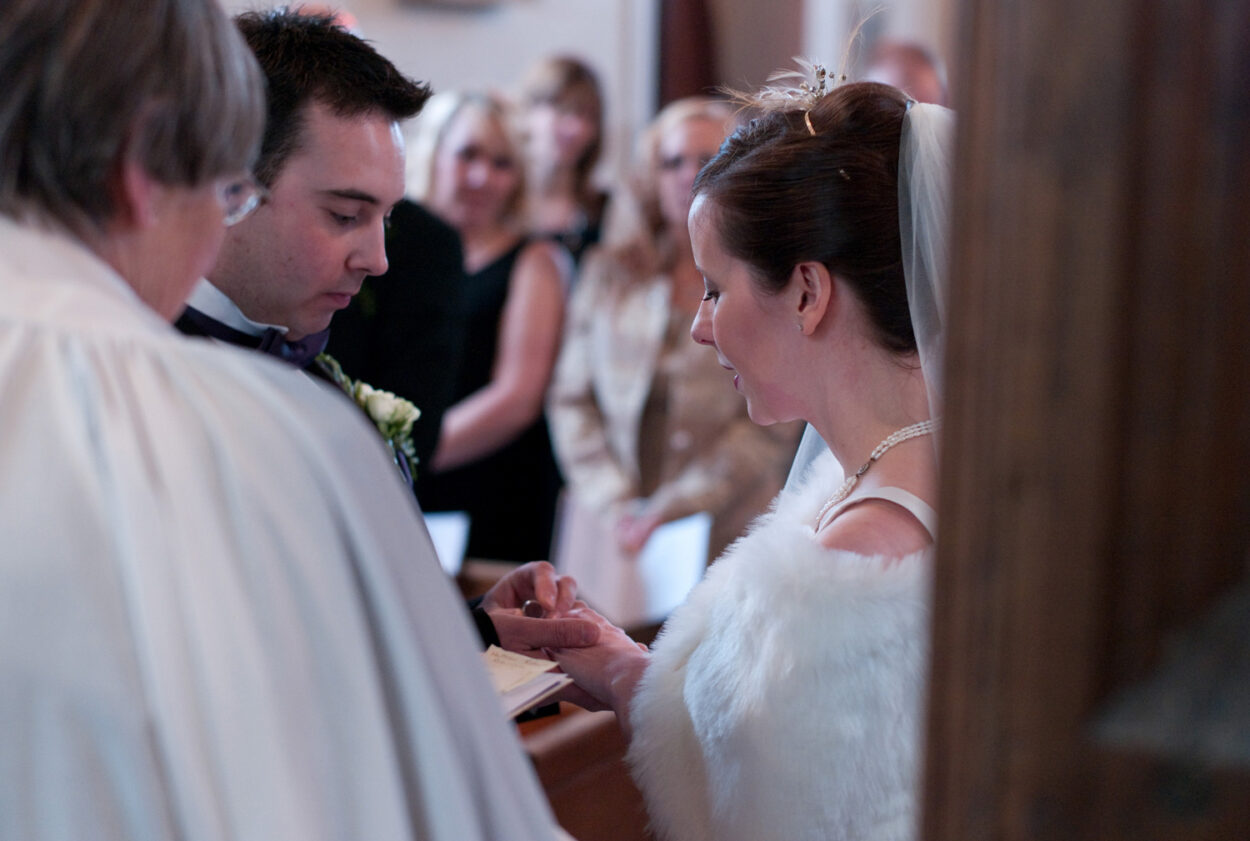 Groom carefully places the ring on Emelie’s finger. 