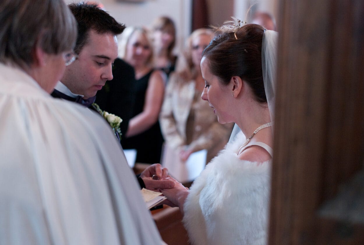 Groom carefully places the ring on Emelie’s finger.