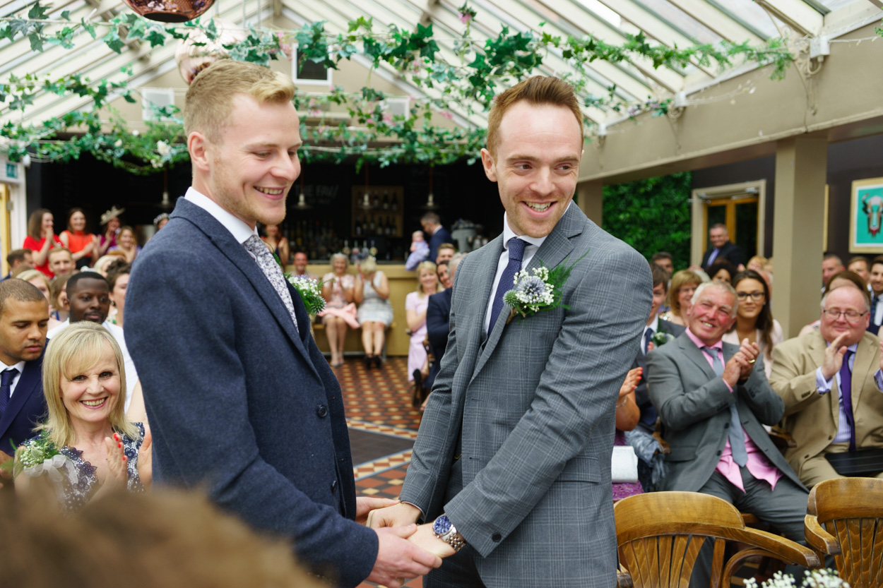 Couple smiling toward the registrar after their first kiss