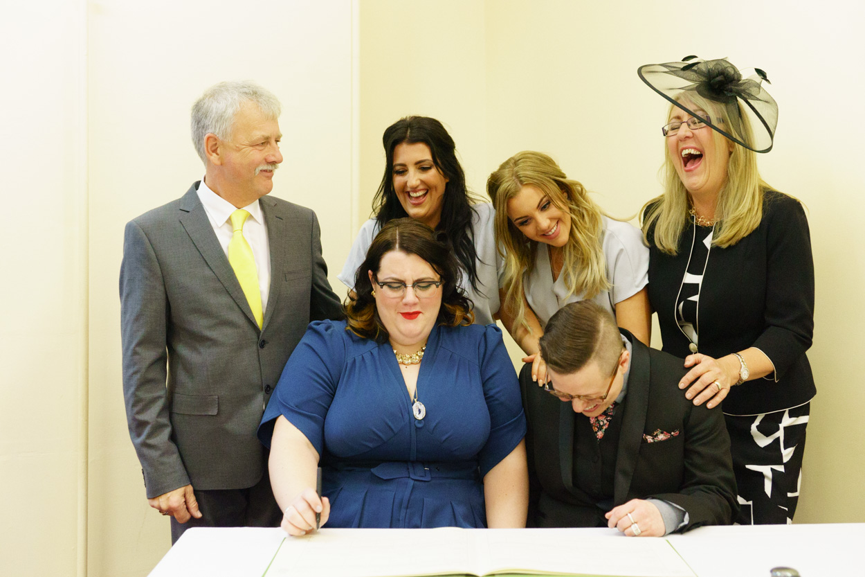 Lizzie’s family gathered smiling around the signing table