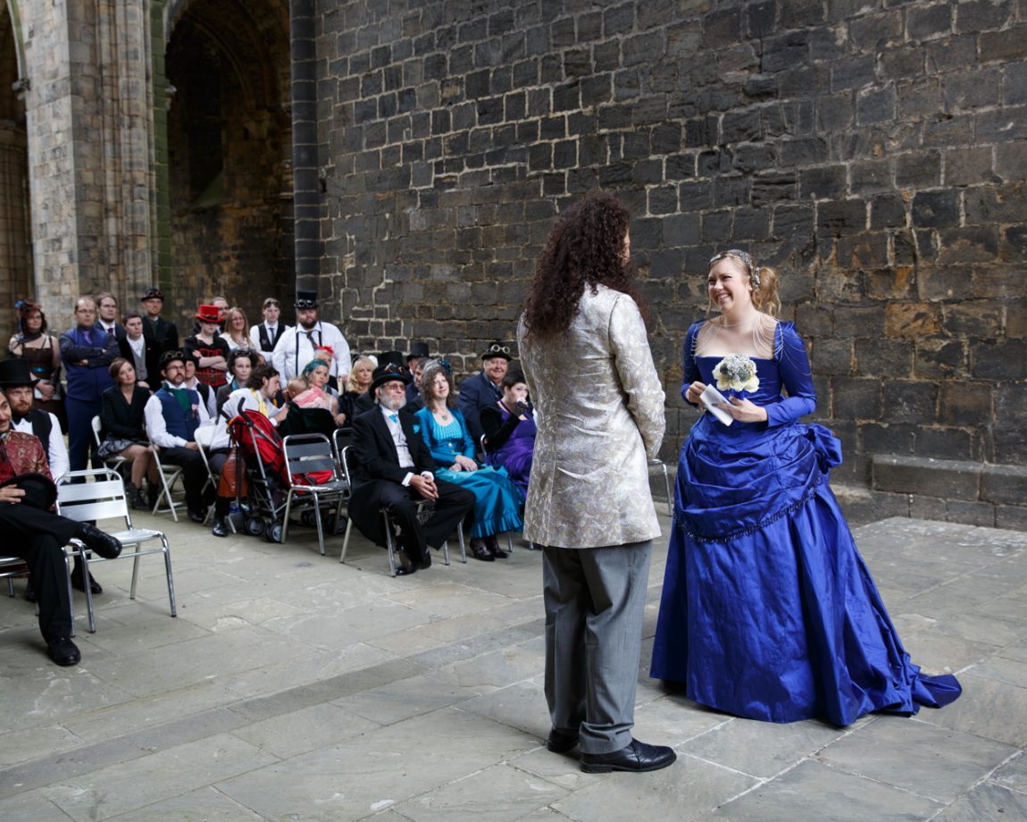 048 bride smiles at her groom as she reads kirkstall abbey wedding linsey and chris