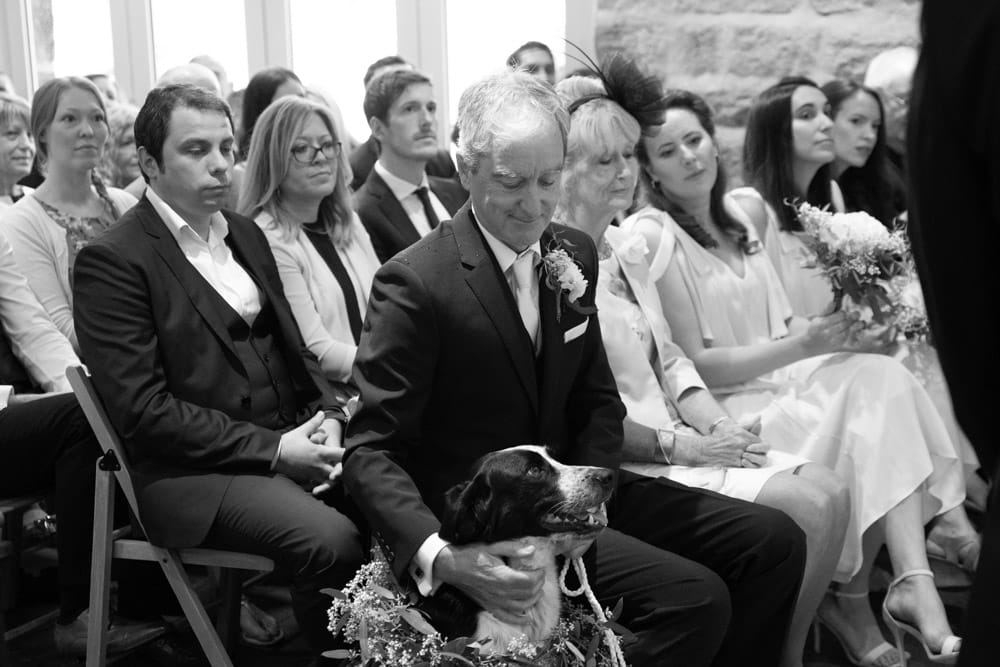 Father of the bride strokes the couple’s rescue dog during the ceremony at the Chilli Barn, Otley.