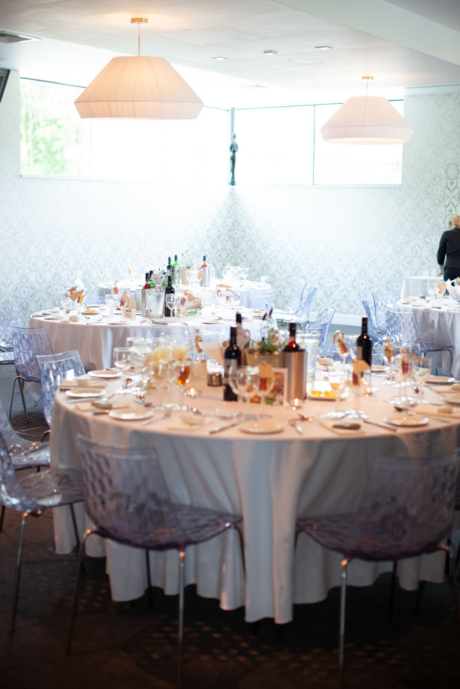 Wedding breakfast room in soft natural light through the windows.