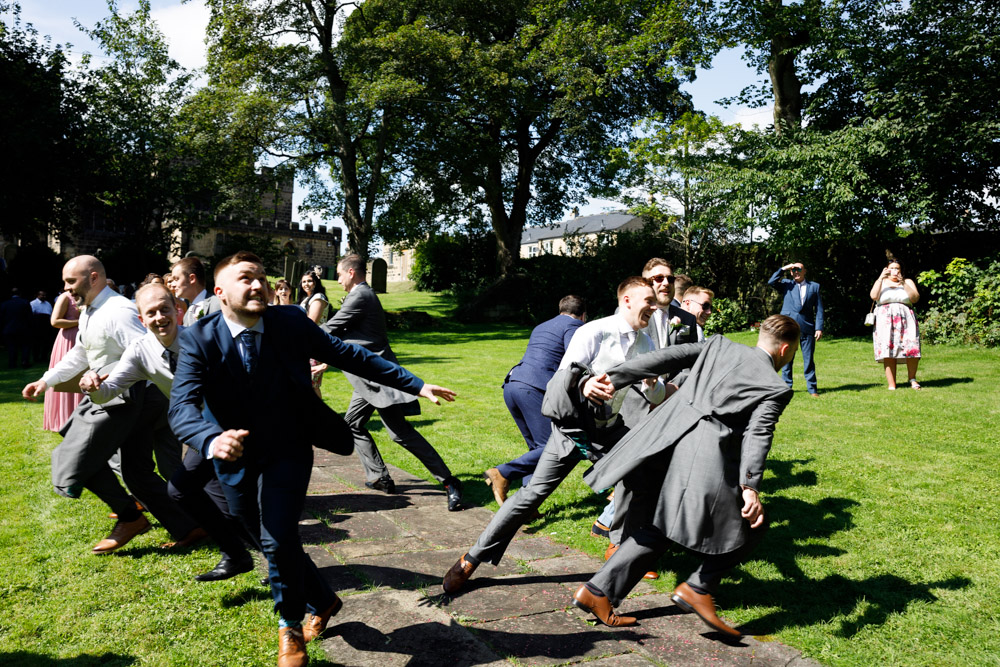 The single male guests humorously scatter in different directions as Matt throws the bouquet.
