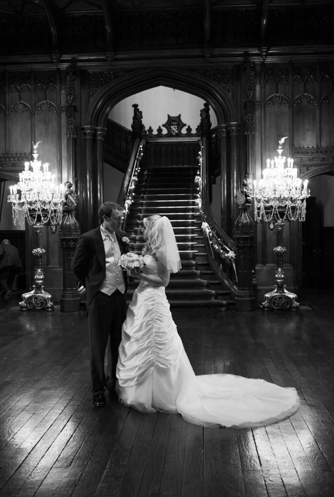 The same staircase moment in black and white, bride and groom gazing at each other.