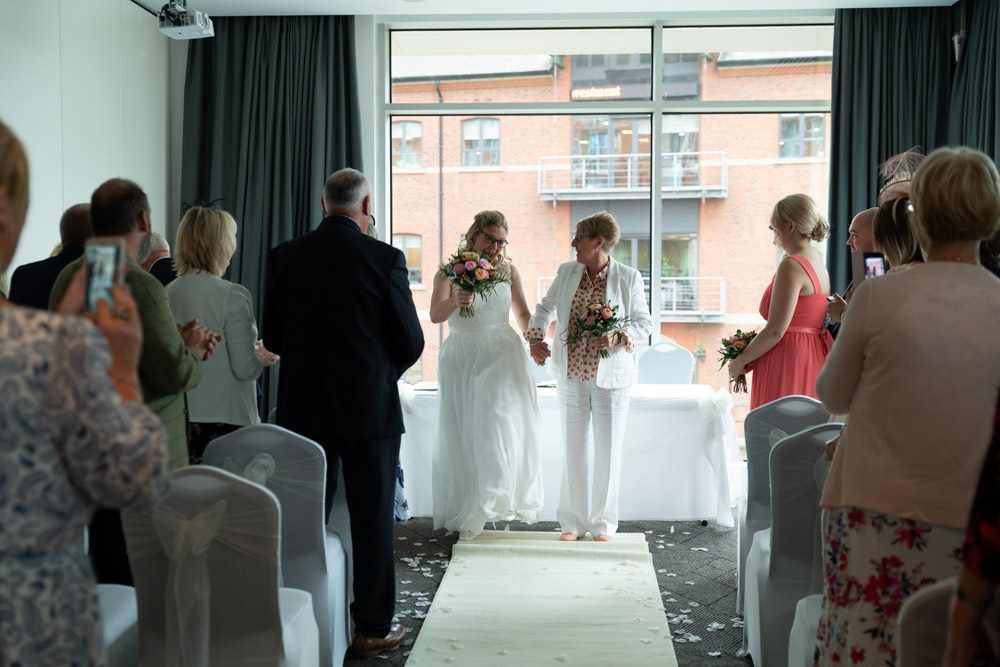 Clare and Tracey begin dancing joyfully down the aisle
