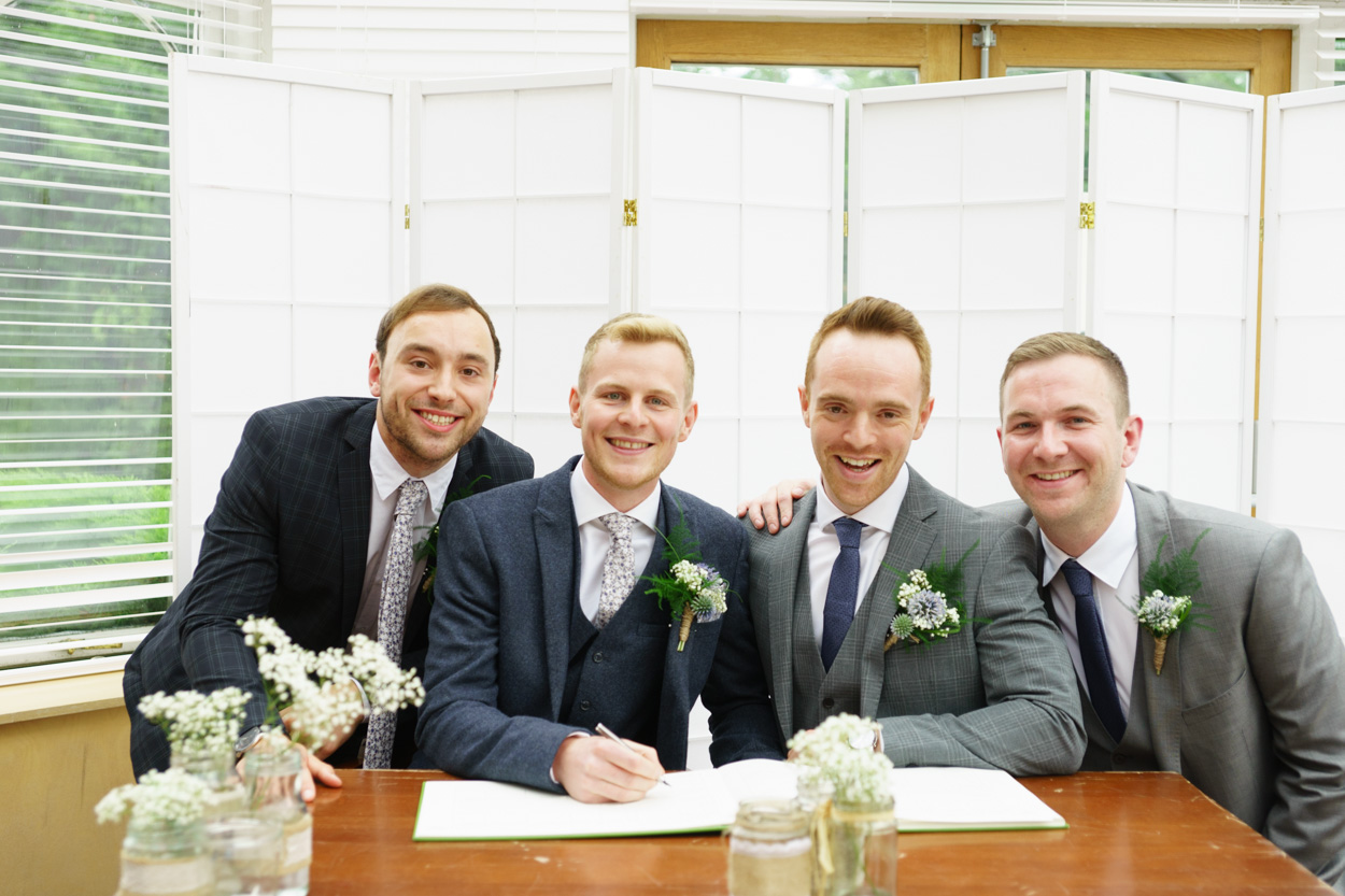 Couple and best men at the signing table