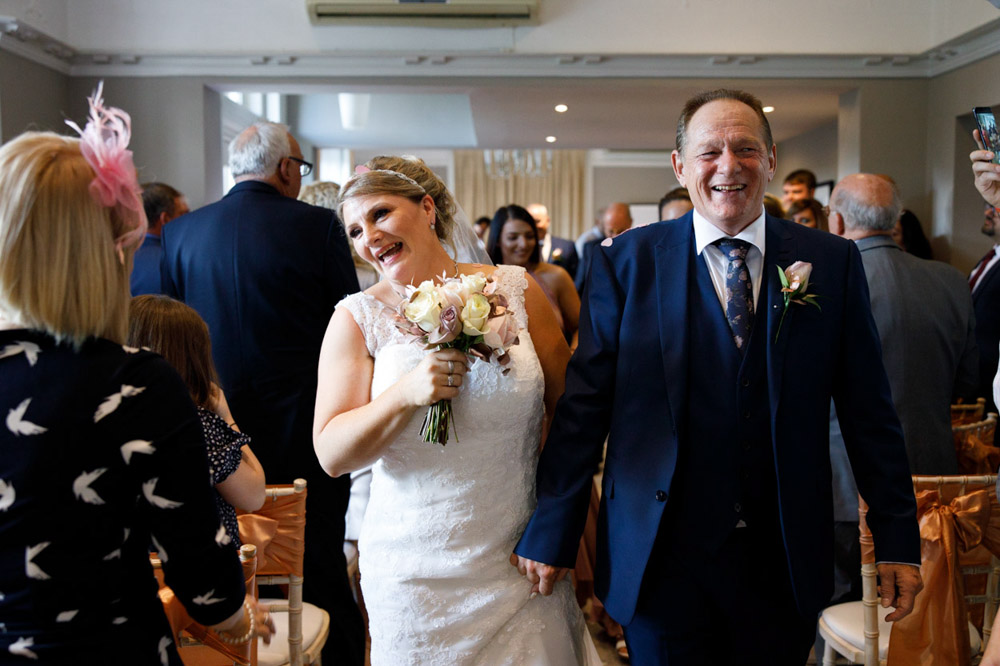 Tracy and Gary smile widely as they reach the doors to exit