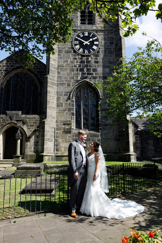 The couple pose beneath the church clock tower reading 1:50pm, ready to leave for Chevin Lodge.