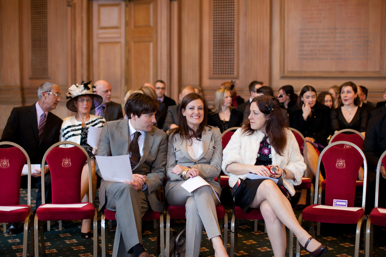 Guests seated on the front row noticing the camera and smiling. 