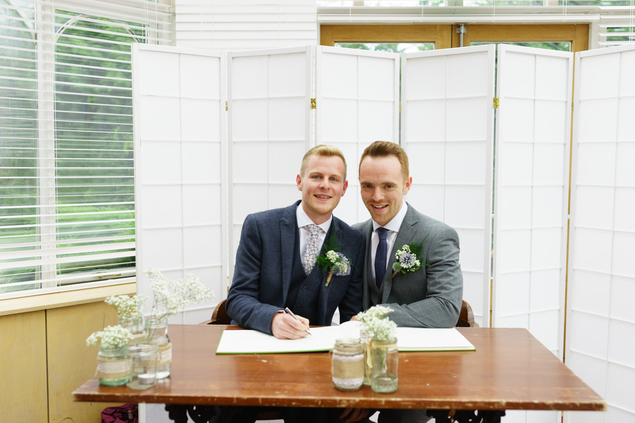 Couple playfully pretending to sign the register