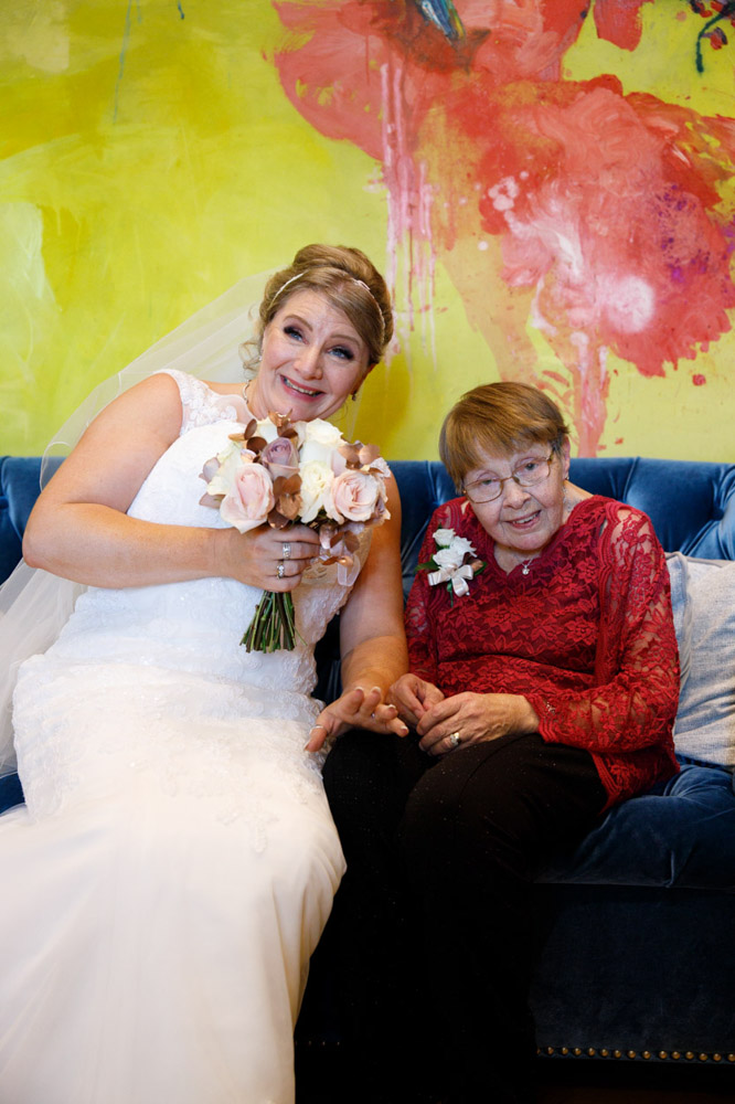 Group photo with Tracy and an elderly guest smiling at different cameras