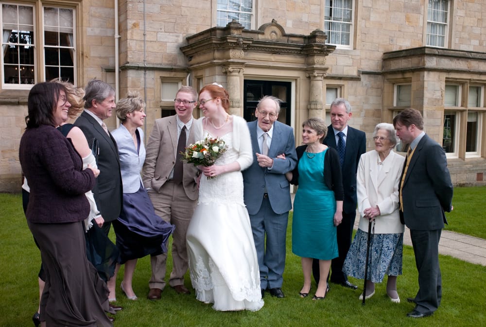 Family group photo outside entrance of Weetwood Hall Leeds, spring wedding.