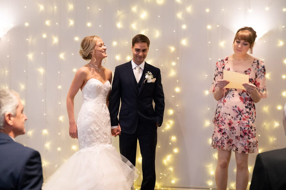 Bride and groom listening intently to the first reading at their Chilli Barn wedding.