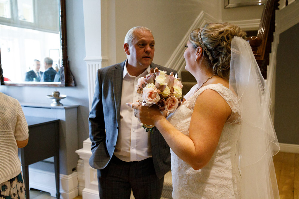 Tracy holding her bouquet while chatting warmly with a guest