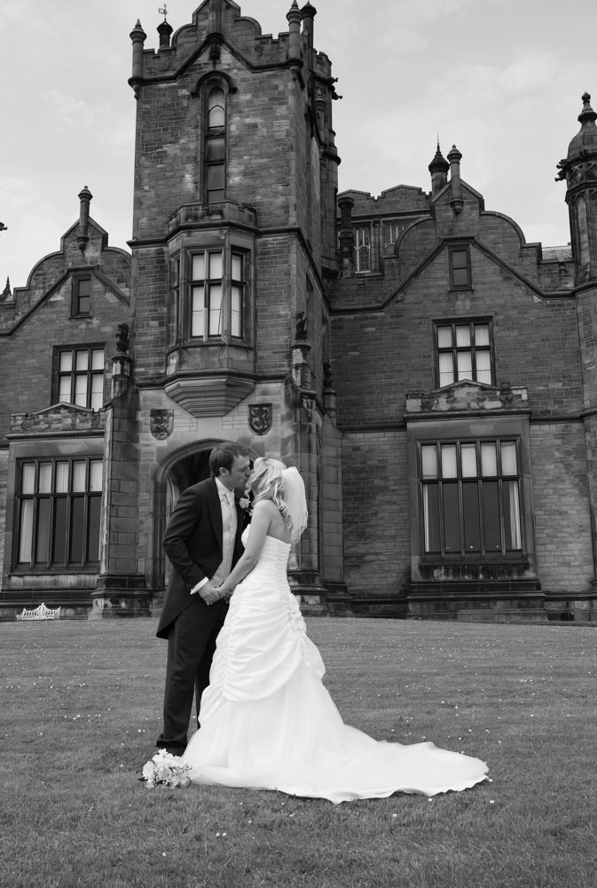 A kiss outside in the cold, with the Yorkshire venue glowing behind them