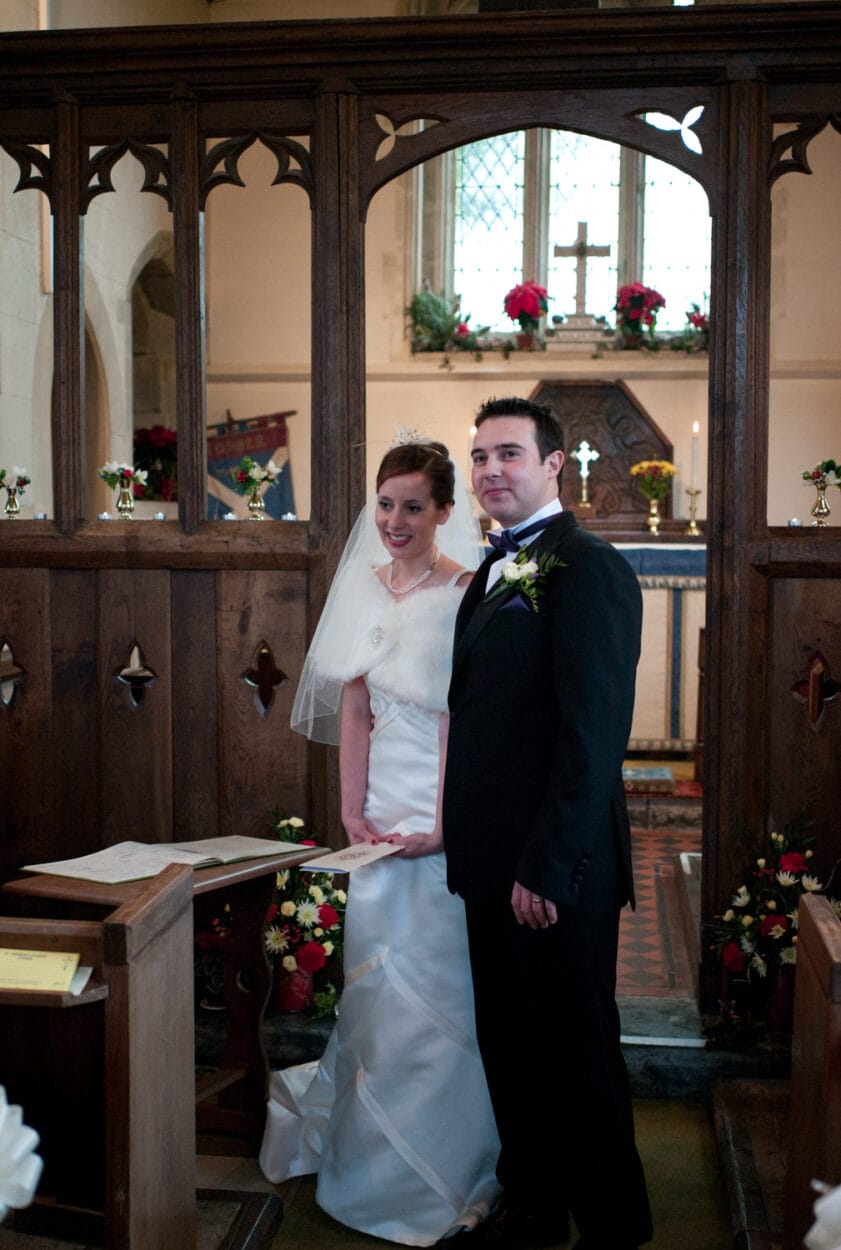The couple smile proudly after signing the register.