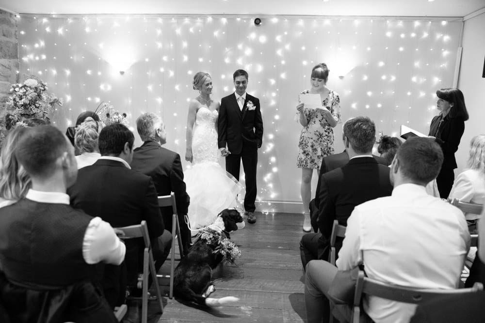 Black and white view from the back as the reading continues at the Chilli Barn wedding ceremony.