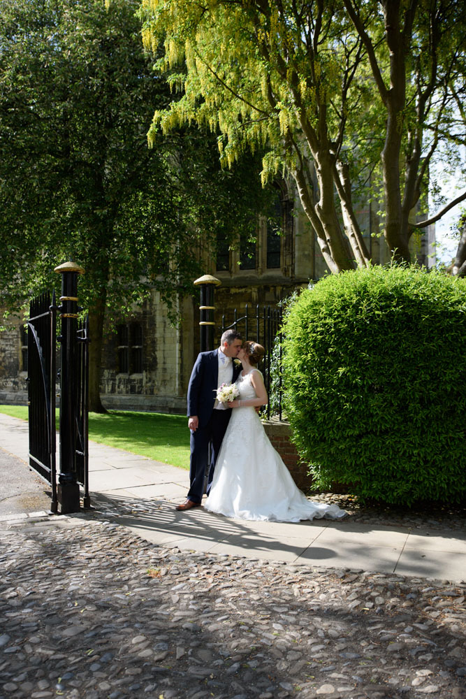 Same portrait position with the couple sharing a kiss by the garden gates.