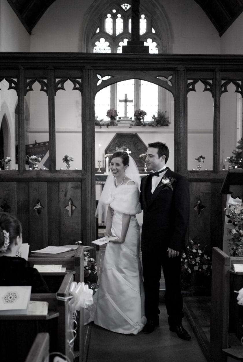 The couple smile so happy looking at family.