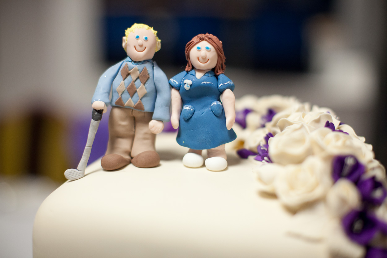Wedding cake topper at Headingley Stadium featuring the groom with a hockey stick and the bride in nurse’s blues.