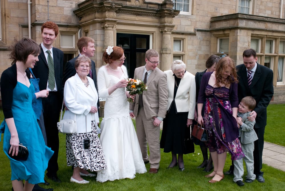 Young boy stealing attention in family group photo at Weetwood Hall, playful moment.