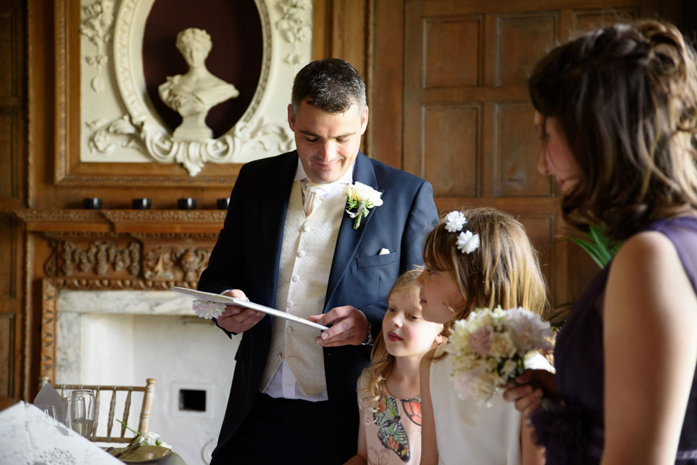 Groom looks at thoughtful handmade gifts from the children.