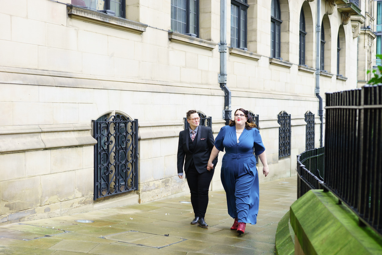 Couple walking outside Sheffield Town Hall toward the Peace Gardens
