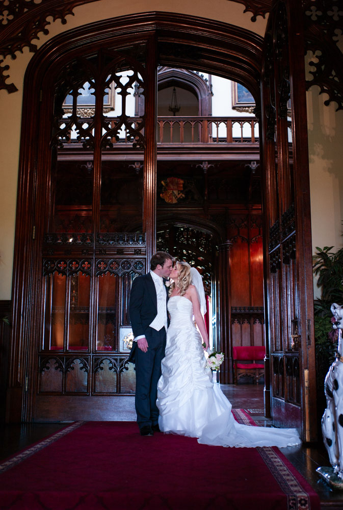 A kiss in front of the tall venue doors, same framing as before