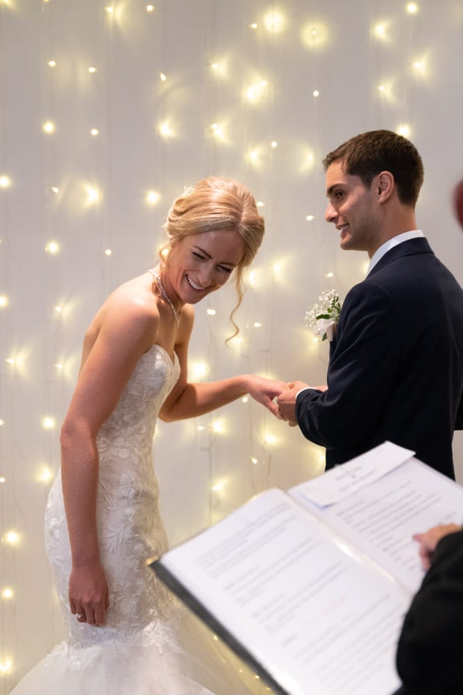 The couple glance back at their family, smiles shared with the room.