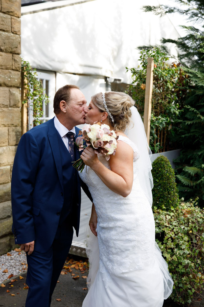 Couple kiss outside the venue in the afternoon light
