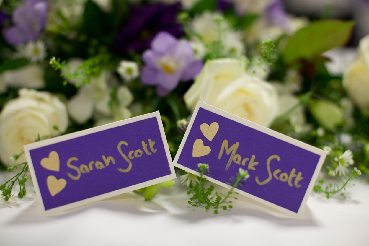 Wedding table centrepieces showing chapters of Sarah and Mark’s journey together.