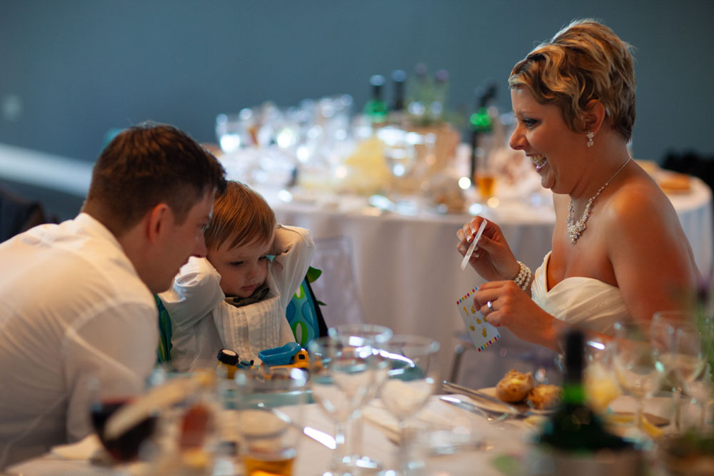 Sam and Tim sit with their young son at the table, enjoying a quiet family moment.