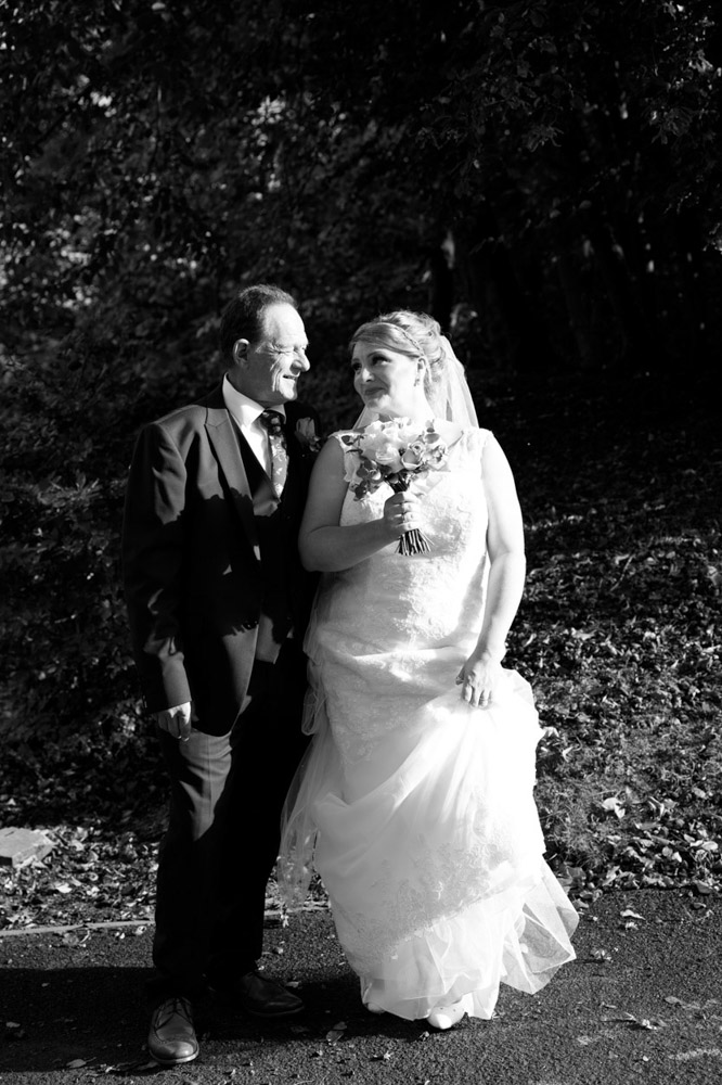 Couple kiss in black and white by the woodland path