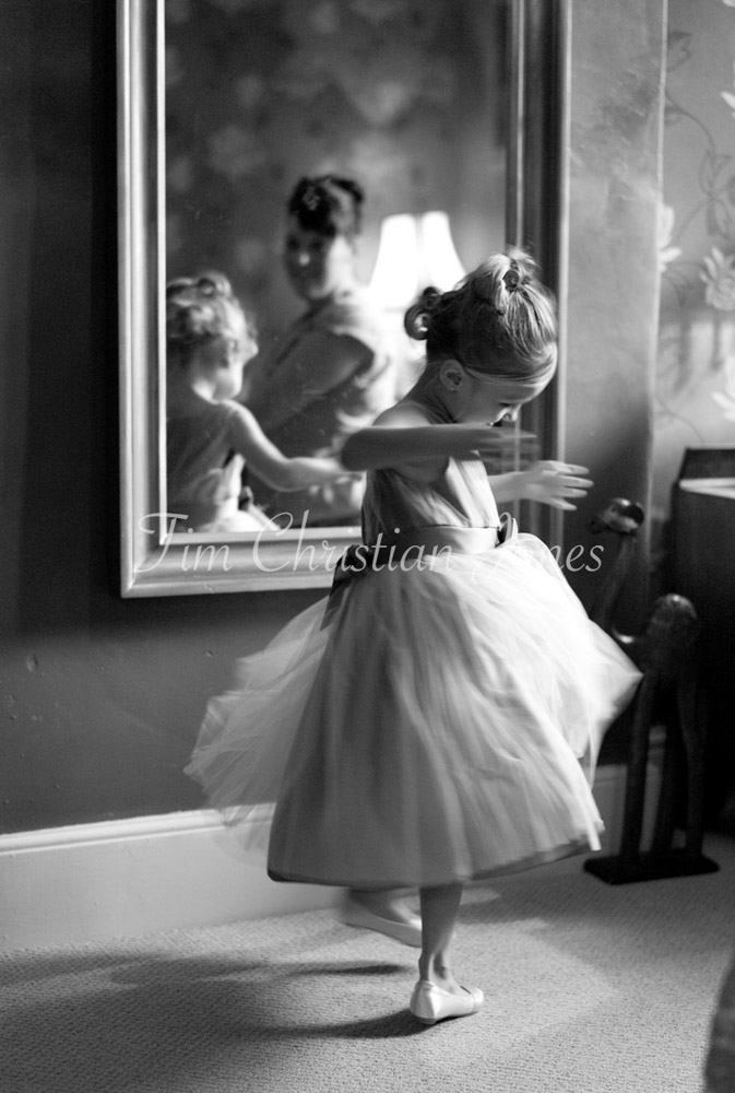 A black and white image of the bridesmaid twirling, dress swirling in soft motion blur.