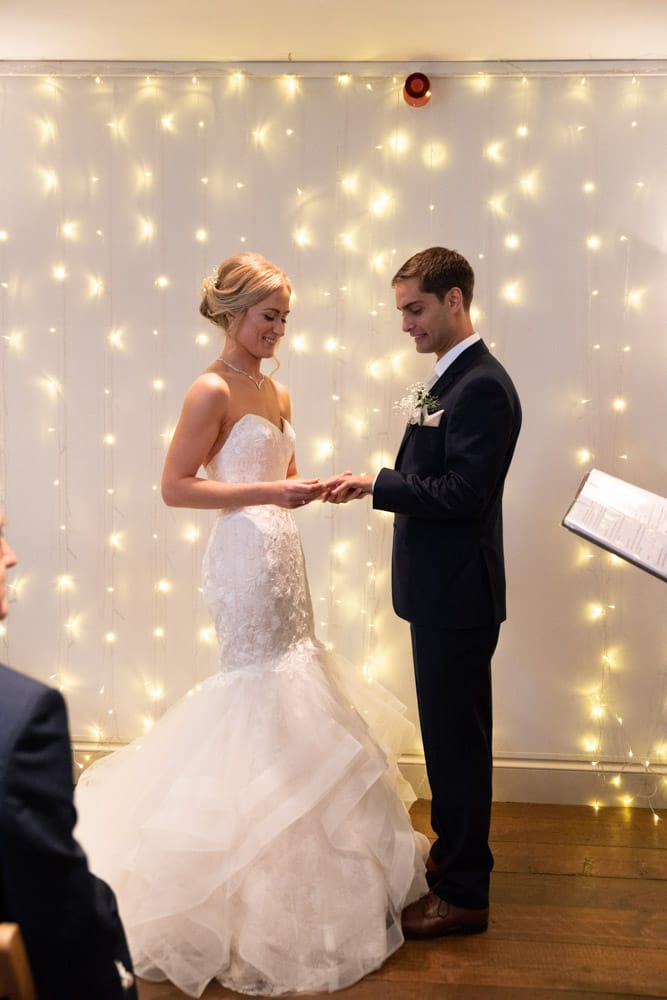 Full-length view as Helen places the ring on Adam’s hand.